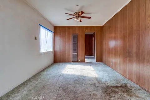 an empty room with fan and windows