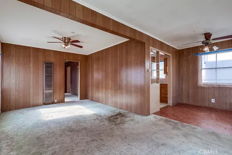 an empty room with windows and chandelier fan