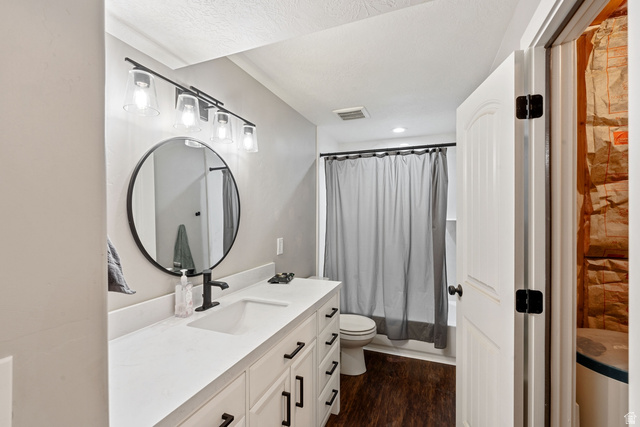 444 South Saddle Road Grantsville, UT 84029 - Photo 20 of 33 Bathroom featuring vanity, dark wood-style flooring, and shower / tub combo