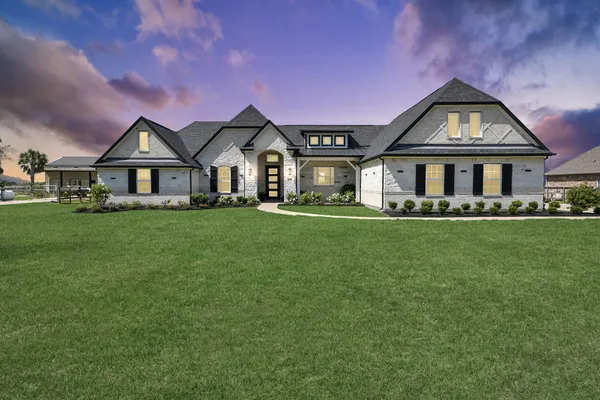 a front view of a house with a garden