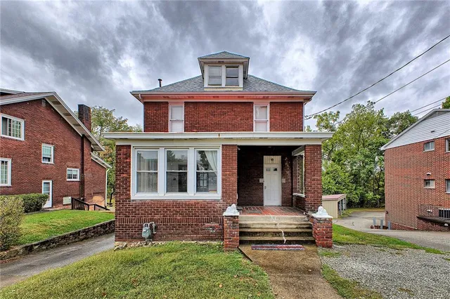 a front view of a house with a garden