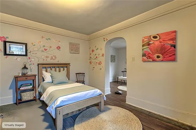 a bedroom with a bed and a painting on the wall