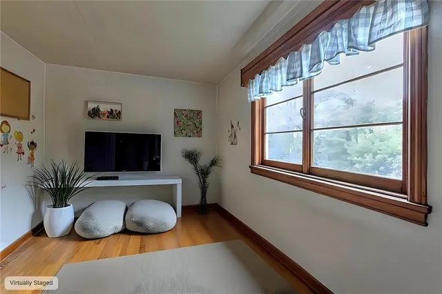a living room with furniture a flat screen tv and a window