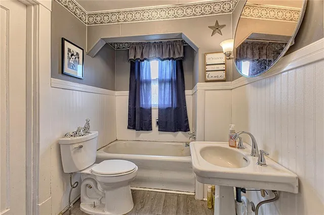 a bathroom with a toilet a sink and a mirror