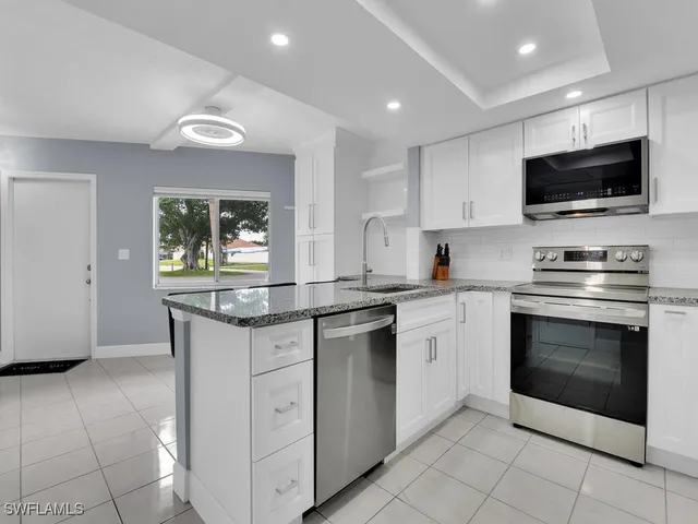 a kitchen with granite countertop a sink and a window