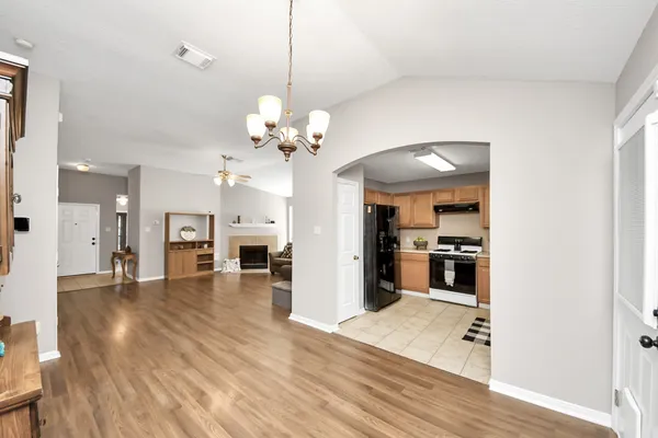 a view of a livingroom with a furniture a chandelier and wooden floor