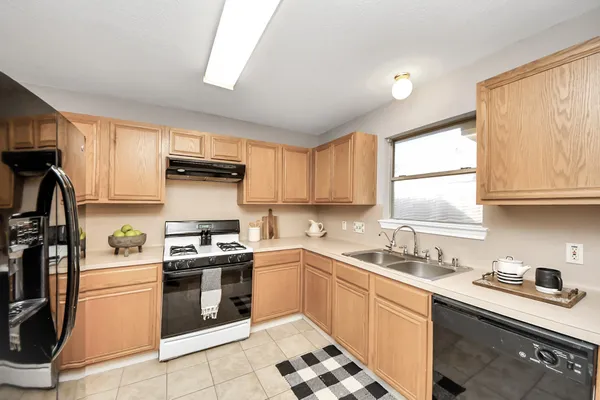 a kitchen with a sink stove top oven and cabinets