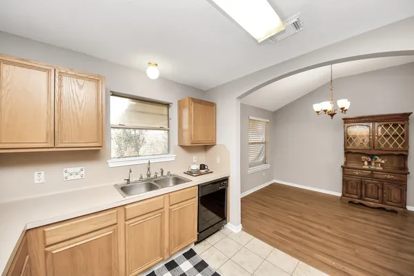 a kitchen with granite countertop a stove cabinets and wooden floor