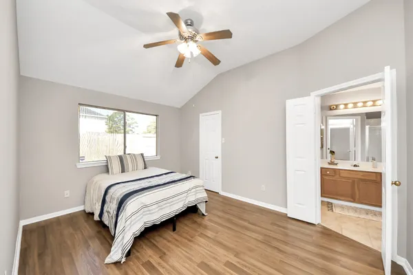 a bedroom with a bed wooden floor and a window