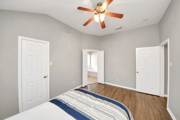 a bedroom with a large bed and a chandelier