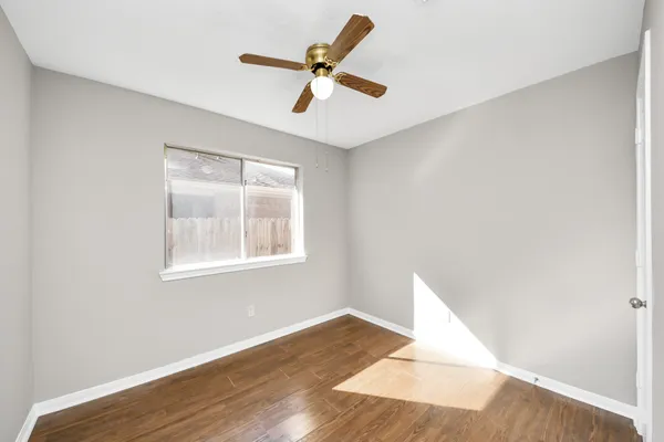 a view of room with wooden floor and ceiling fan