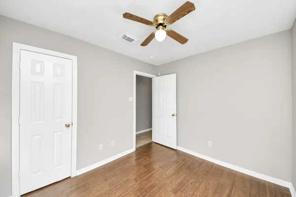 a view of empty room with wooden floor