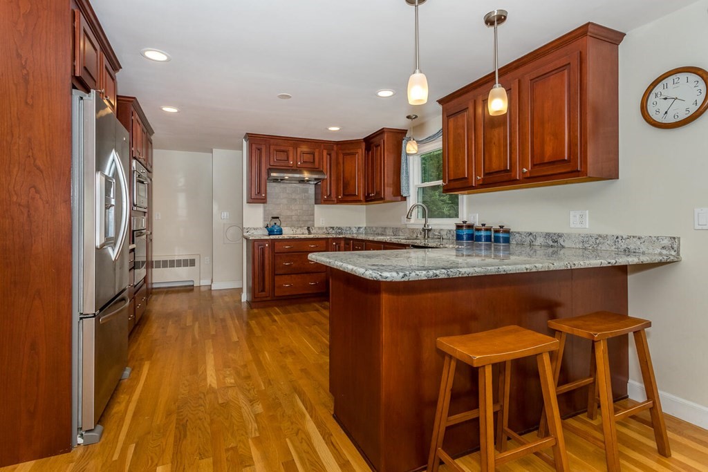 24 Mohawk Road Canton, MA 02021 - Photo 9 of 34 a kitchen with granite countertop wooden floors and refrigerator