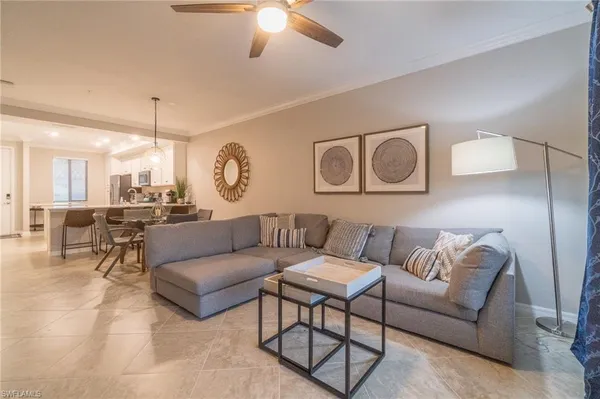 a living room with furniture kitchen view and a chandelier