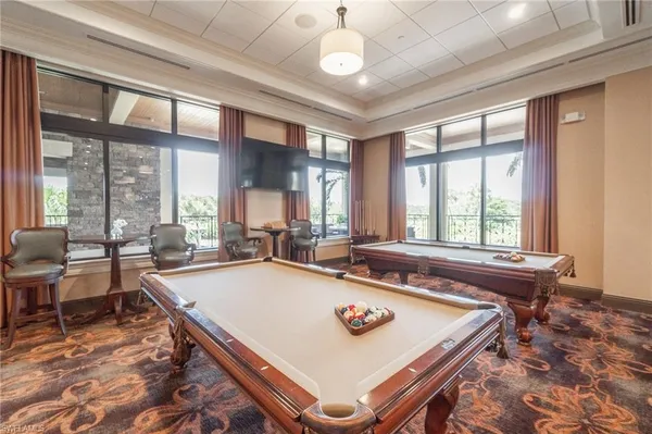 a room with pool table and windows