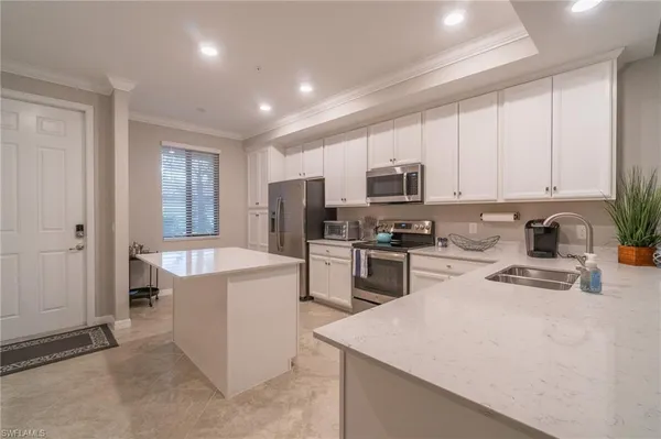 a kitchen with stainless steel appliances granite countertop a refrigerator sink and stove