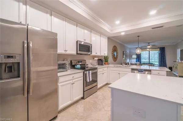a kitchen with kitchen island a counter top space stainless steel appliances and cabinets