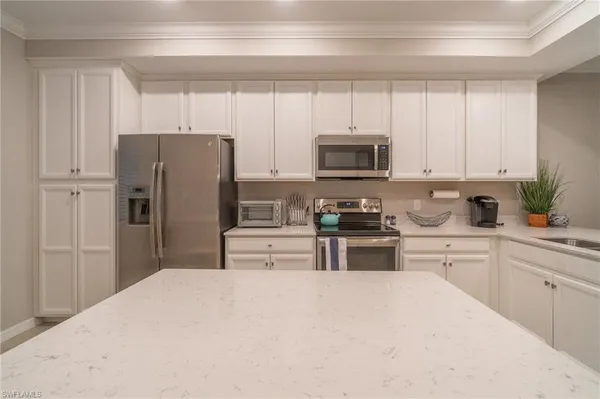 a kitchen with refrigerator a microwave a sink and cabinets