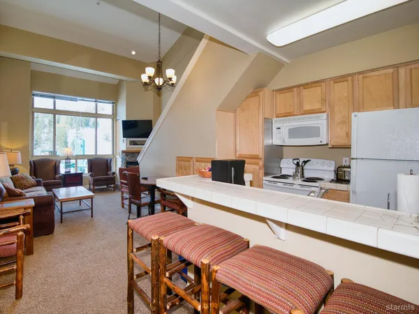 a large kitchen with a table chairs refrigerator and cabinets