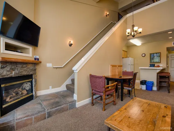 a living room with furniture a flat screen tv and kitchen view