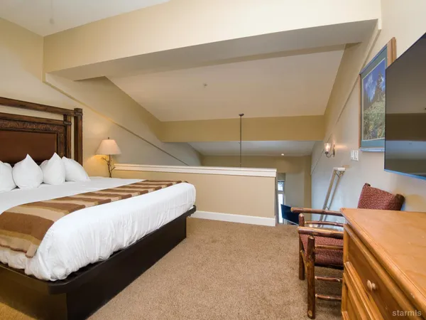 a bedroom with bed and wooden floor