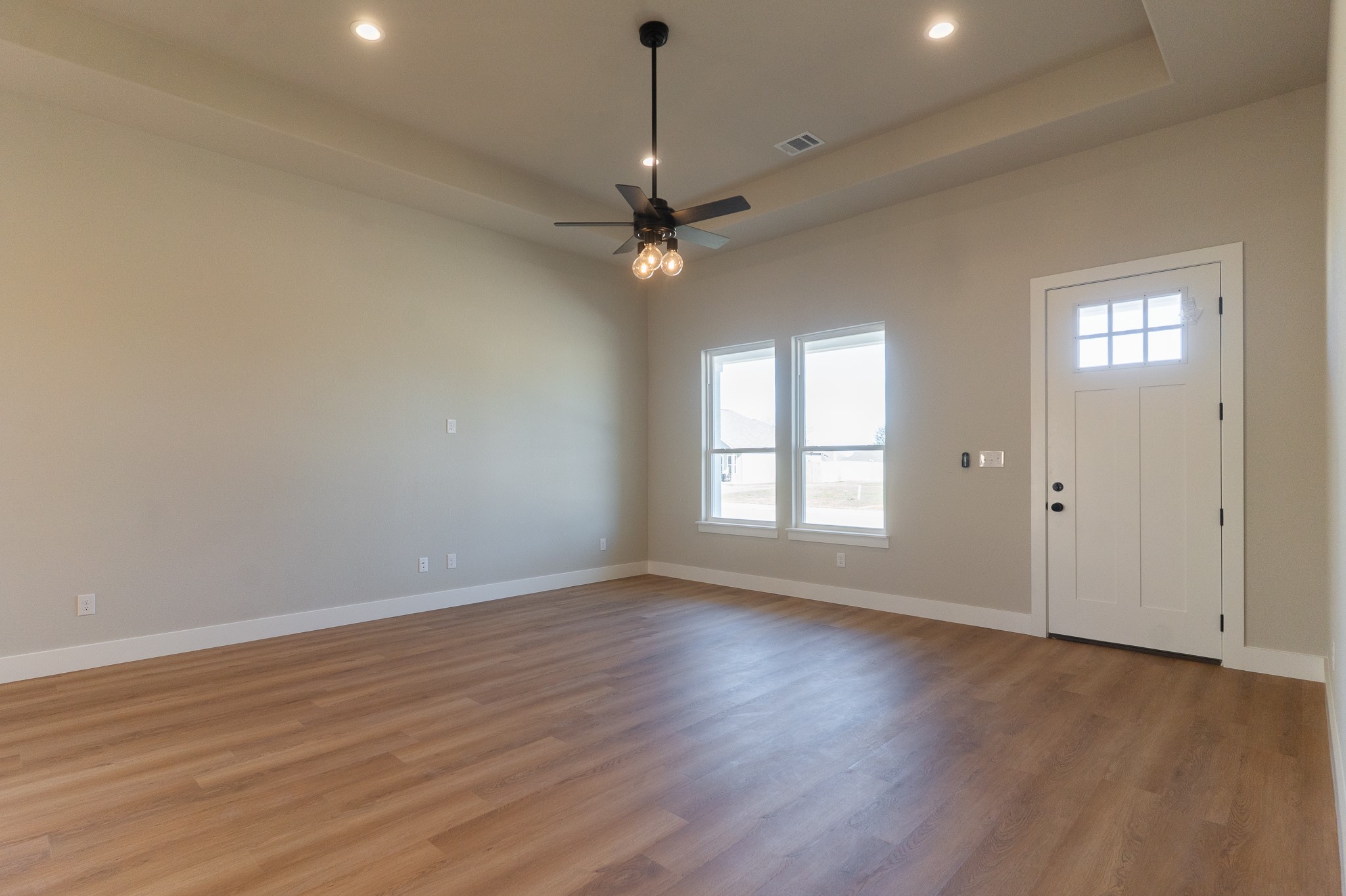 313 String Prairie Way Smithville, TX 78957 - Photo 6 of 18 a view of an empty room with window and wooden floor