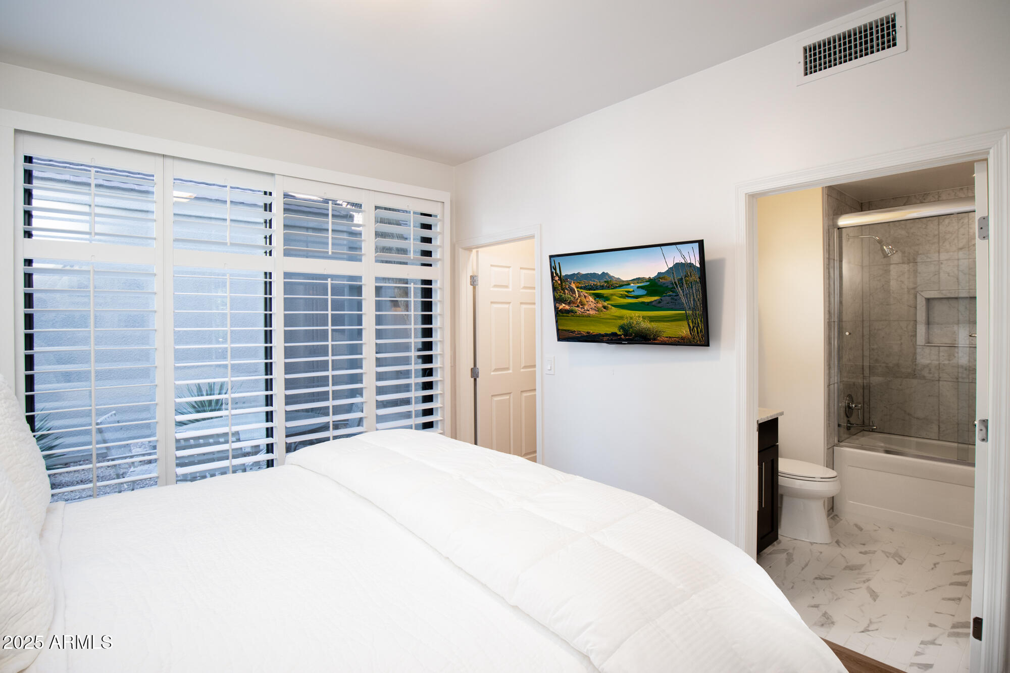 7700 East Gainey Ranch Road, Unit 125 Scottsdale, AZ 85258 - Photo 24 of 46 a bedroom with a bed and a view of bathroom