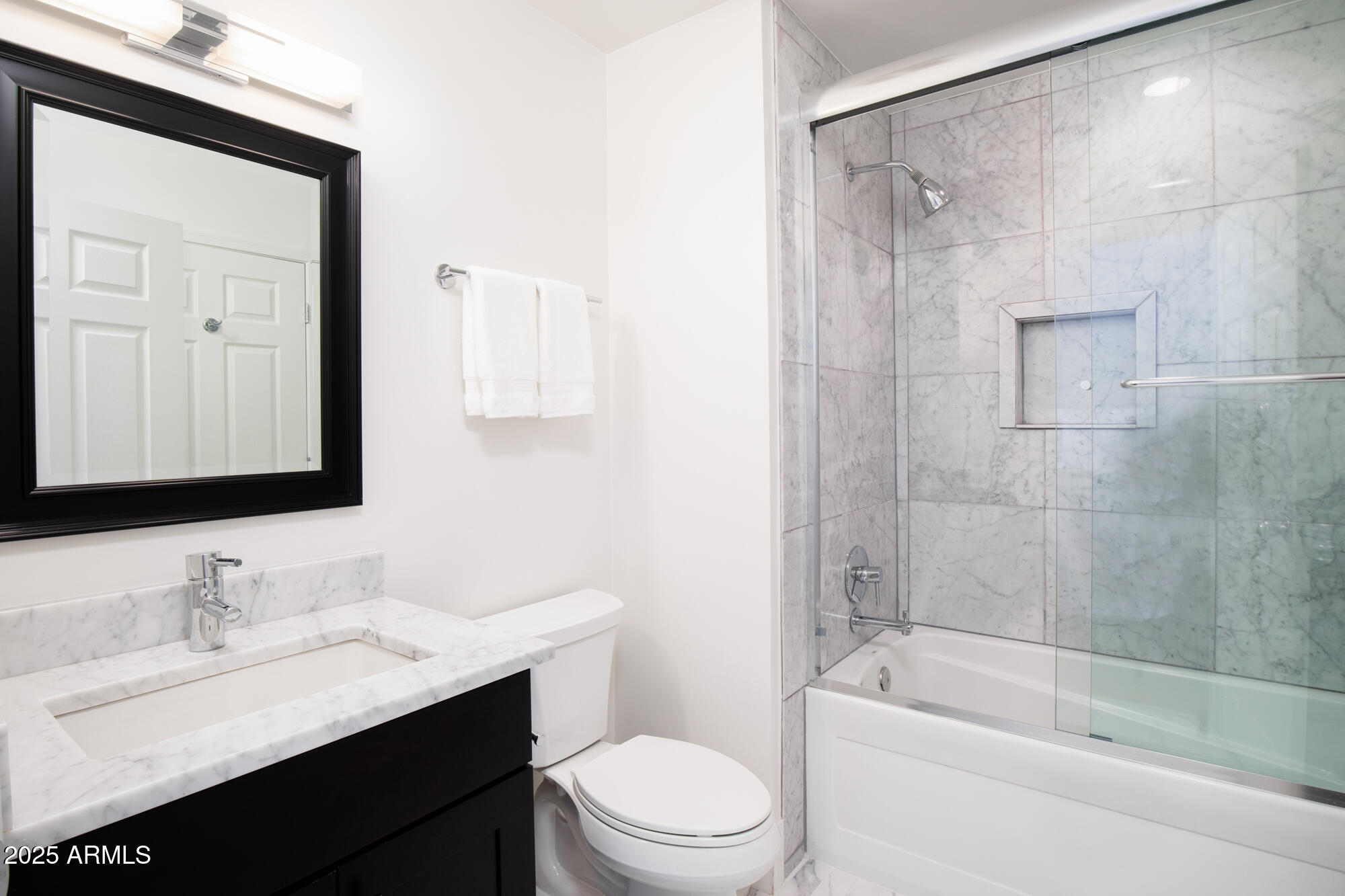 7700 East Gainey Ranch Road, Unit 125 Scottsdale, AZ 85258 - Photo 26 of 46 a bathroom with a granite countertop sink toilet a large mirror a shower and bathtub