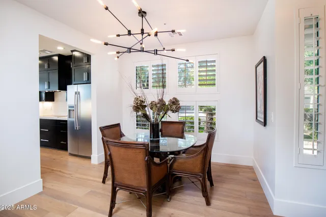 a dining room with furniture a chandelier and window