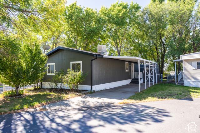 96 Barrington Way Layton, UT 84041 - Photo 2 of 18 Dark-toned exterior siding with white trim windows and a covered carport entry