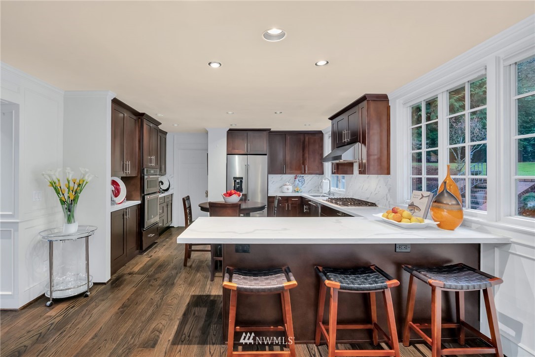 3808 Hunts Point Road Hunts Point, WA 98004 - Photo 21 of 24 a kitchen with stainless steel appliances a table and chairs in it