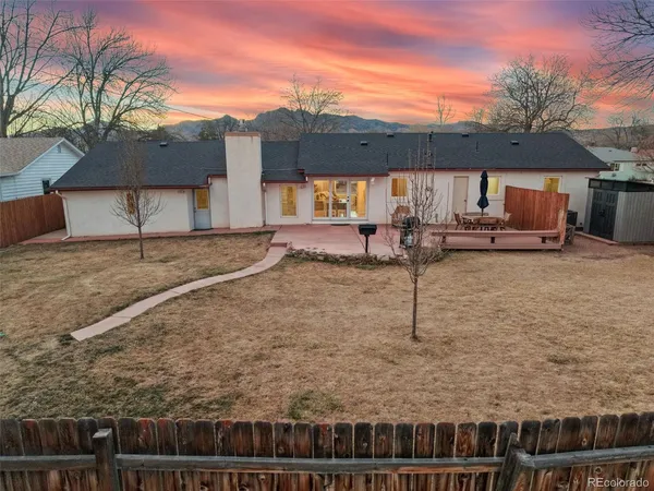 a view of a house with backyard and sitting area