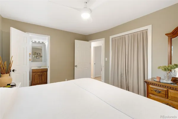 a bedroom with a large bed and dresser with mirror