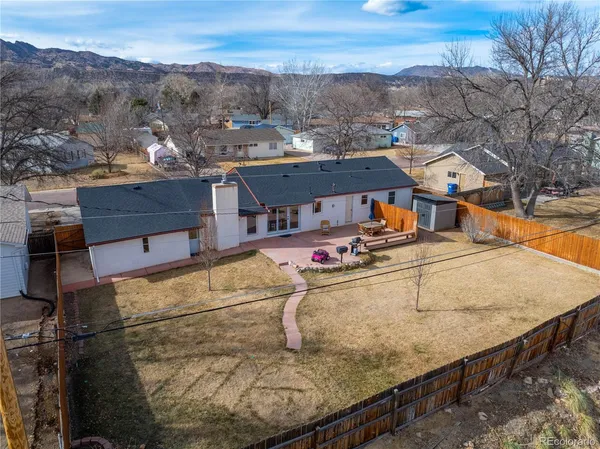 an aerial view of a house with a yard basket ball court and mountain view in back