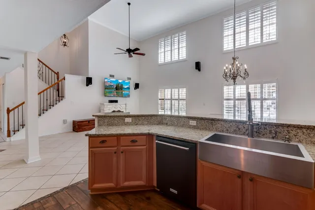 a kitchen with granite countertop a sink a counter space appliances and windows