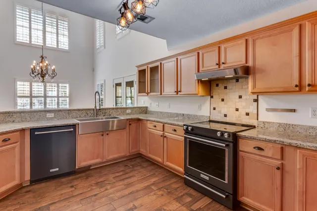 a kitchen with stainless steel appliances granite countertop a stove sink and cabinets