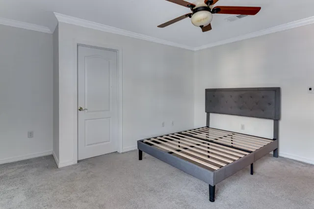 a living room with a bed and a ceiling fan