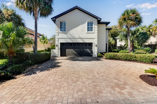 a view of a house with a yard and palm trees