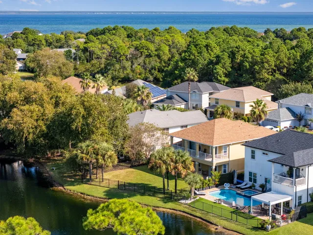 an aerial view of residential houses with outdoor space and swimming pool