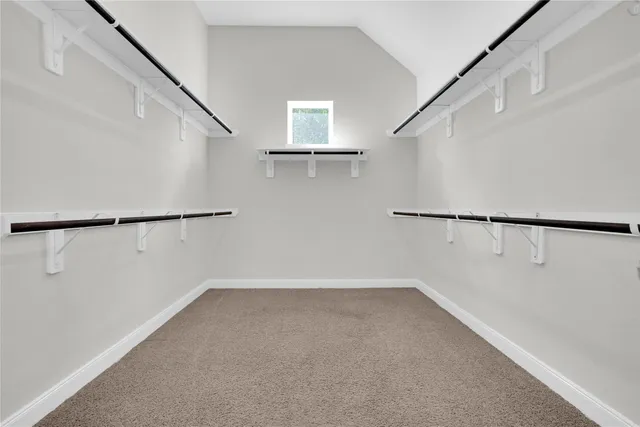 a large kitchen with stainless steel appliances a large counter top a stove and a refrigerator