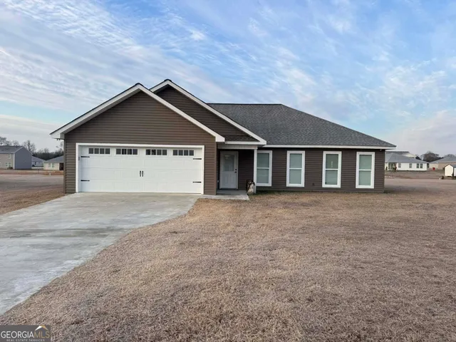 a view of a house with a yard and garage