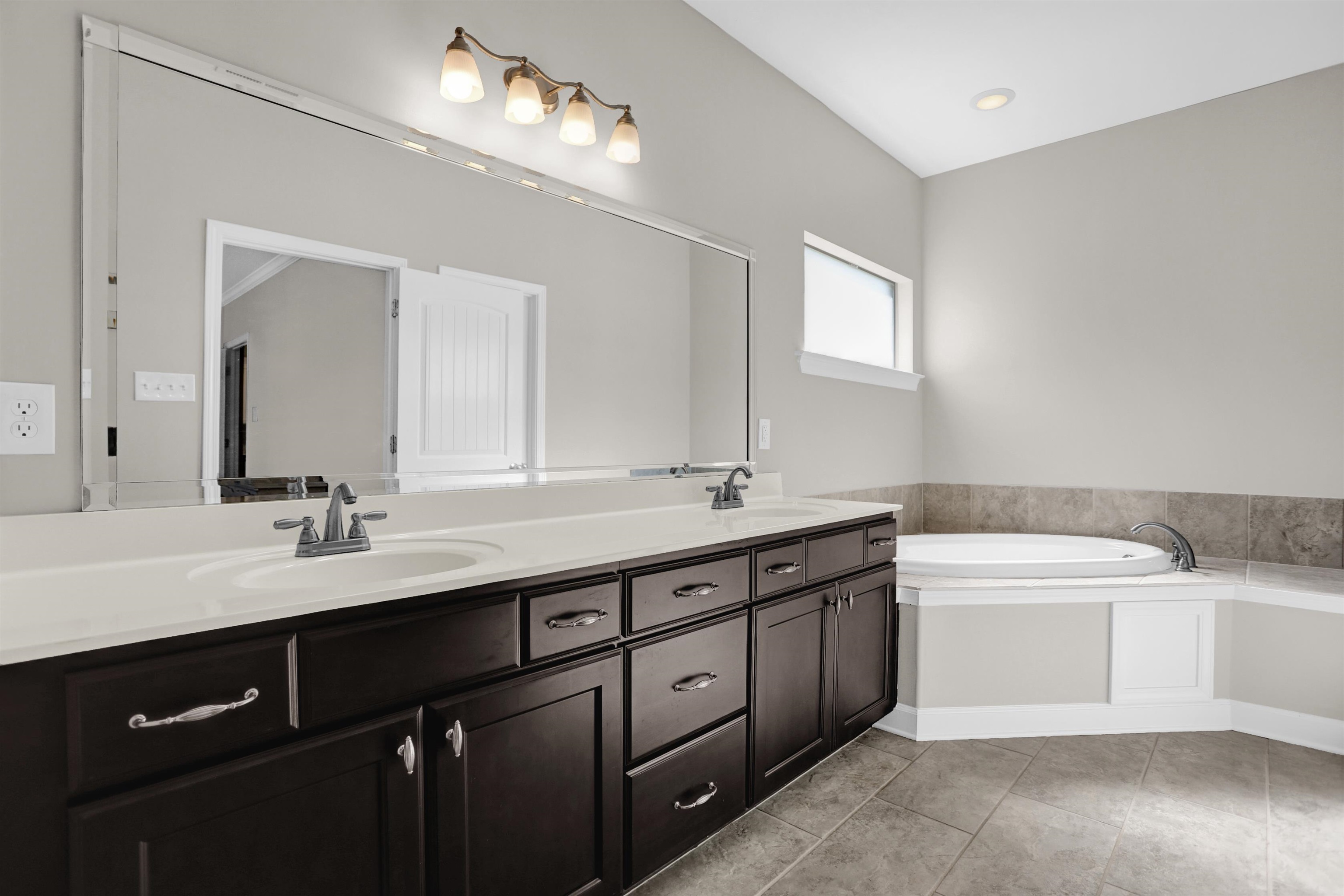25 Breezy Loop Oakland, TN 38060 - Photo 10 of 19 a bathroom with a double vanity sink a mirror and a bathtub