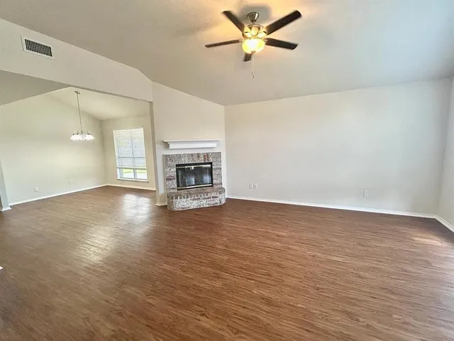 a view of empty room with wooden floor and fireplace