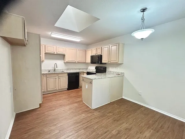 a kitchen with a sink window and cabinets