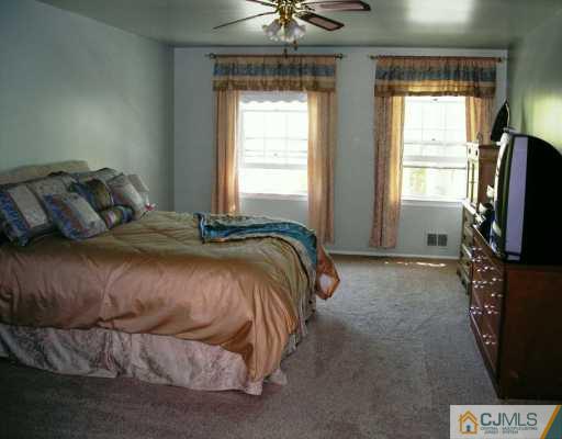 21 Thomas Road East Brunswick, NJ 08816 - Photo 5 of 8 a bedroom with a bed television and a window