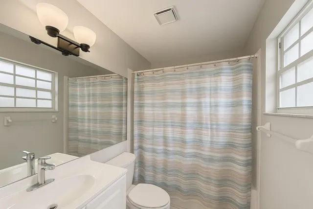 a bathroom with a sink toilet and shower curtain
