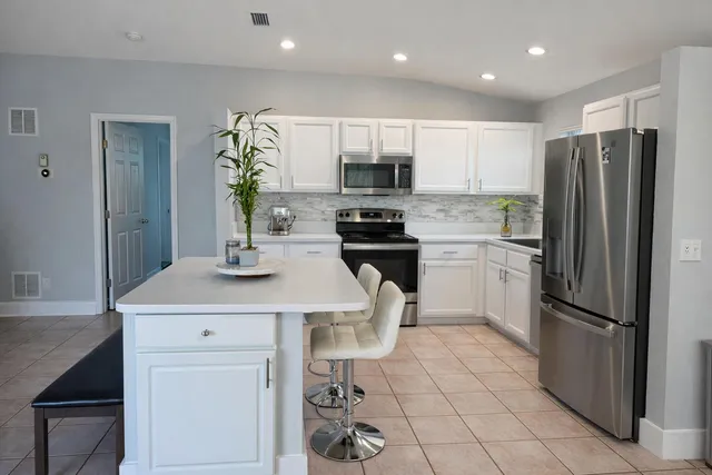 a kitchen with stainless steel appliances a refrigerator sink and microwave