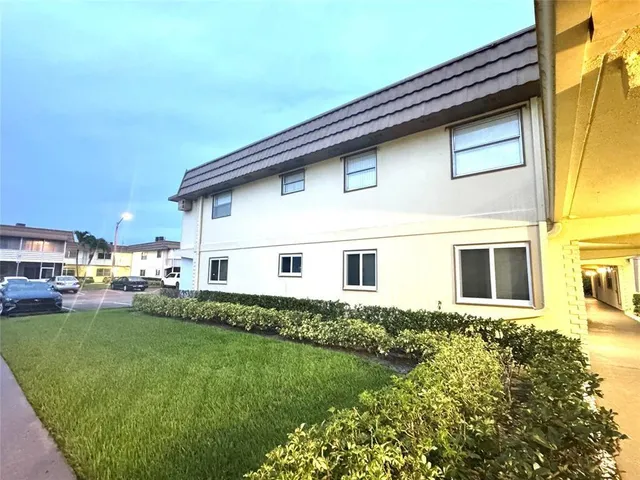 a white house that has tree in front of it