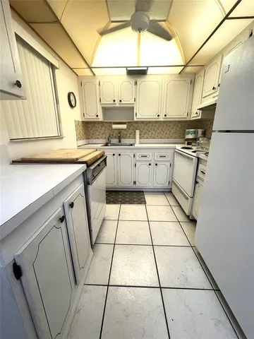 a kitchen with a sink a stove a refrigerator and cabinets