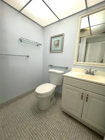 a bathroom with a toilet a sink and mirror